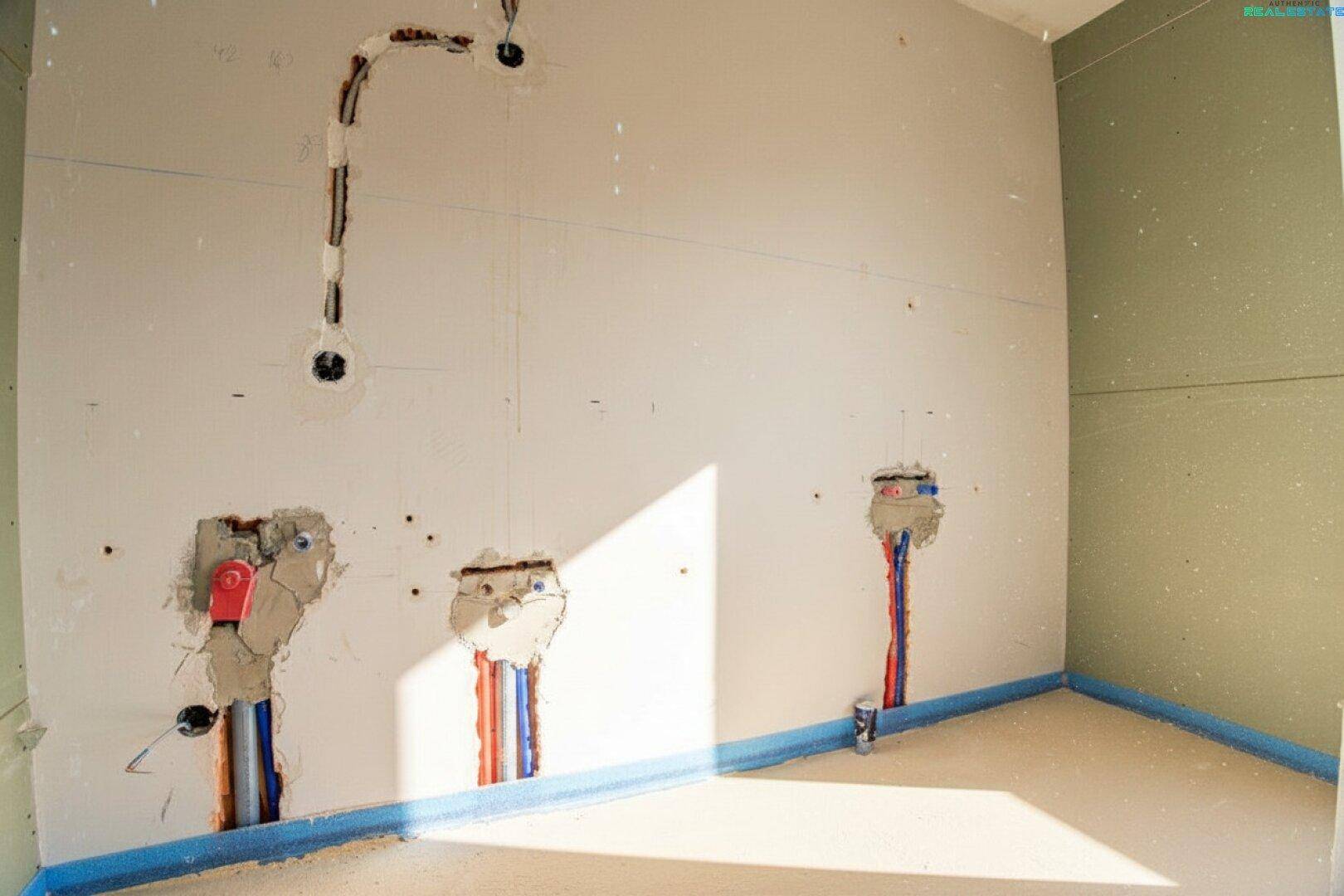 Badezimmer im Rohbau mit vorbereiteten Wasseranschlüssen und Trockenbauwänden.