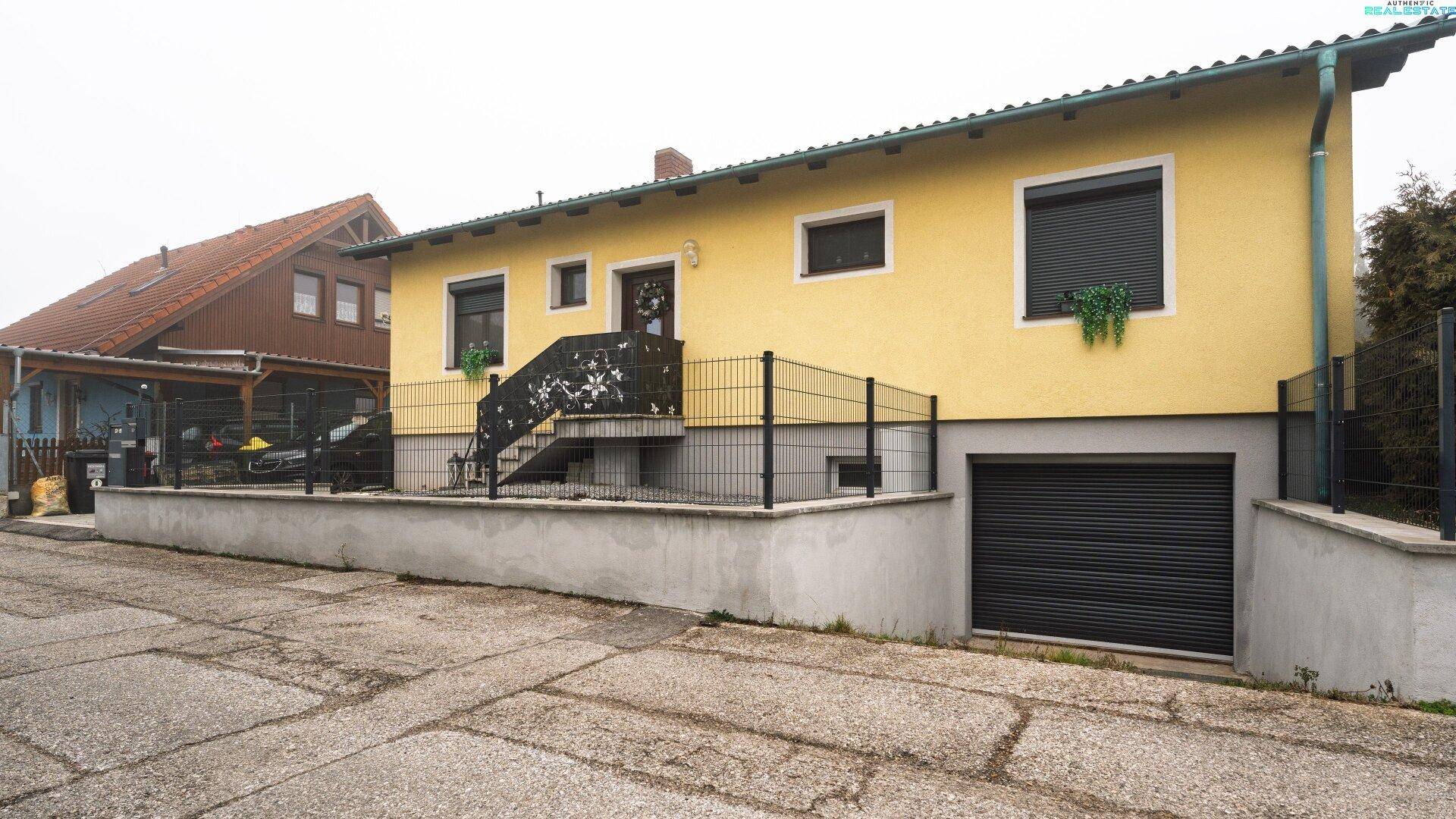 Vorderansicht des Hauses mit Eingangsbereich, Garage und Zufahrt.