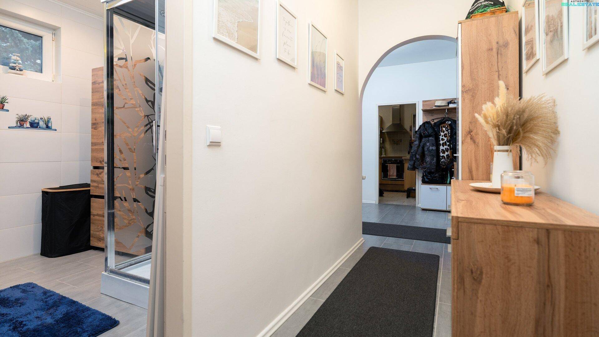 Flur mit Zugang zum Badezimmer und weiteren Räumen.