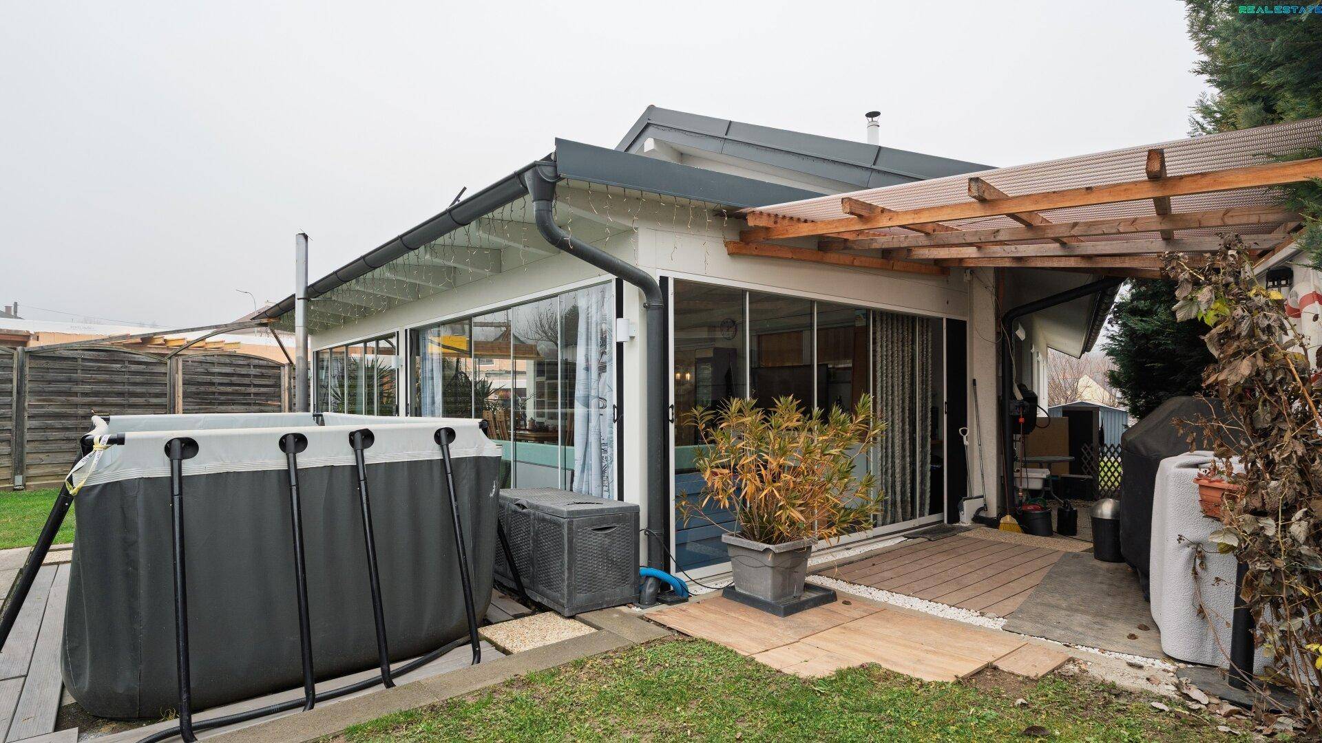 Detailansicht des Aufstellpools im Garten mit angrenzender Terrasse und überdachtem Bereich.