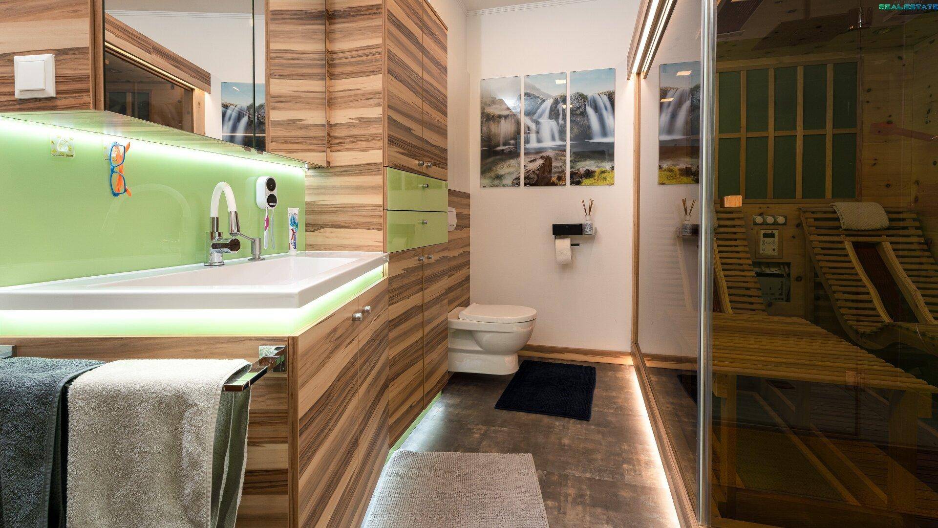 Modernes Badezimmer mit Sauna, Waschtisch, Toilette und Holzakzenten.