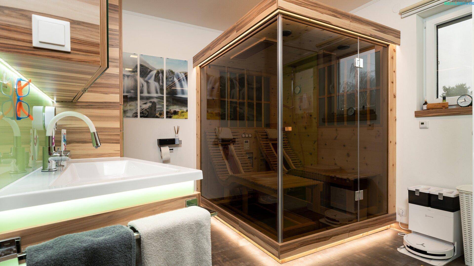Modernes Badezimmer mit integrierter Sauna, Waschtisch und indirekter Beleuchtung.