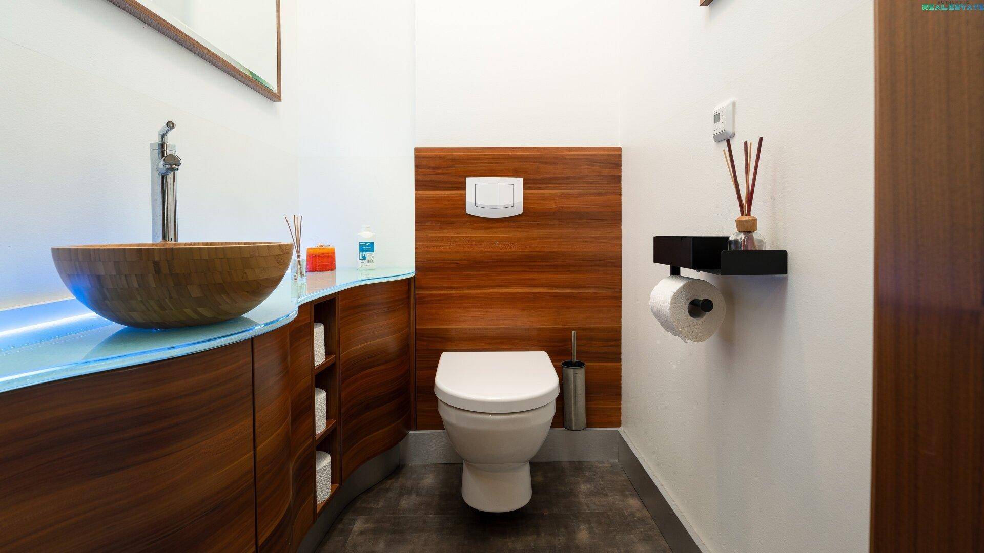 Stilvolles Gäste-WC mit Holzwaschbecken, Wand-WC und Holzwandverkleidung.