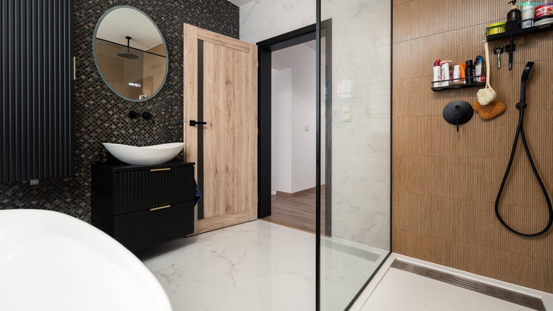 Stilvolles Badezimmer mit runden Spiegeln, begehbarer Dusche und modernen Armaturen, elegant und geräumig.