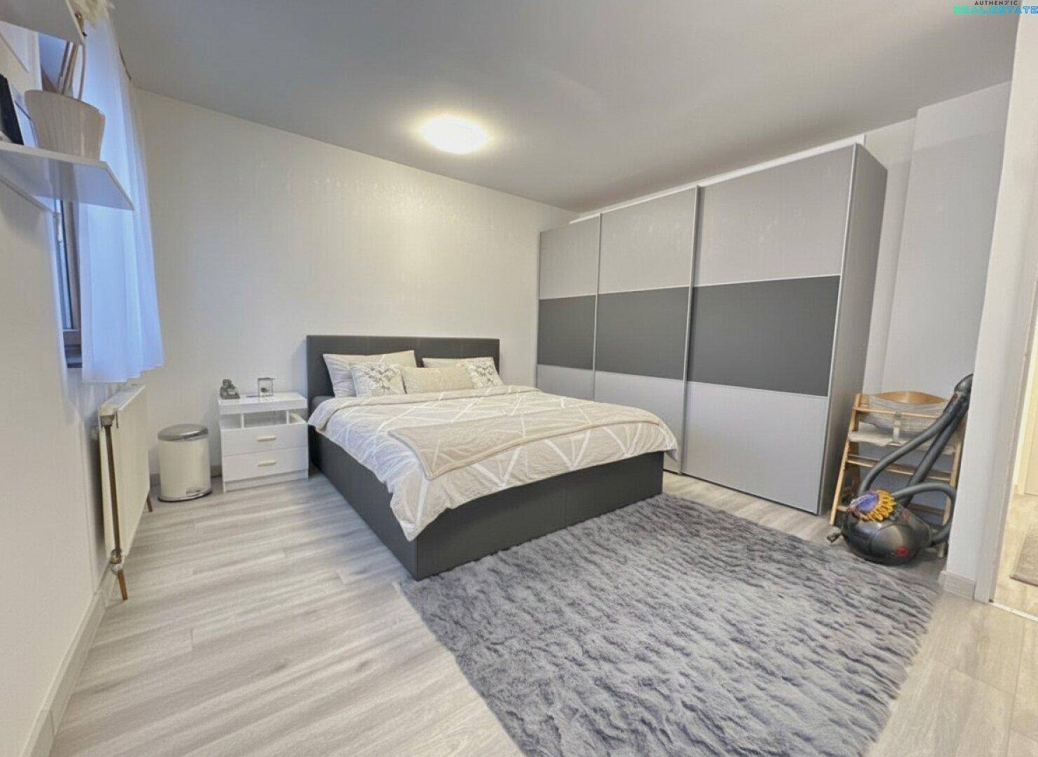 Geräumiges Schlafzimmer mit großem Kleiderschrank, Doppelbett und hellem Laminatboden für Komfort.