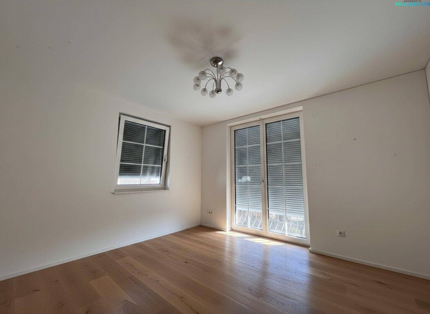 Geräumiges Zimmer mit Holzboden und Fenstern mit Rollläden für Privatsphäre und Sonnenschutz.