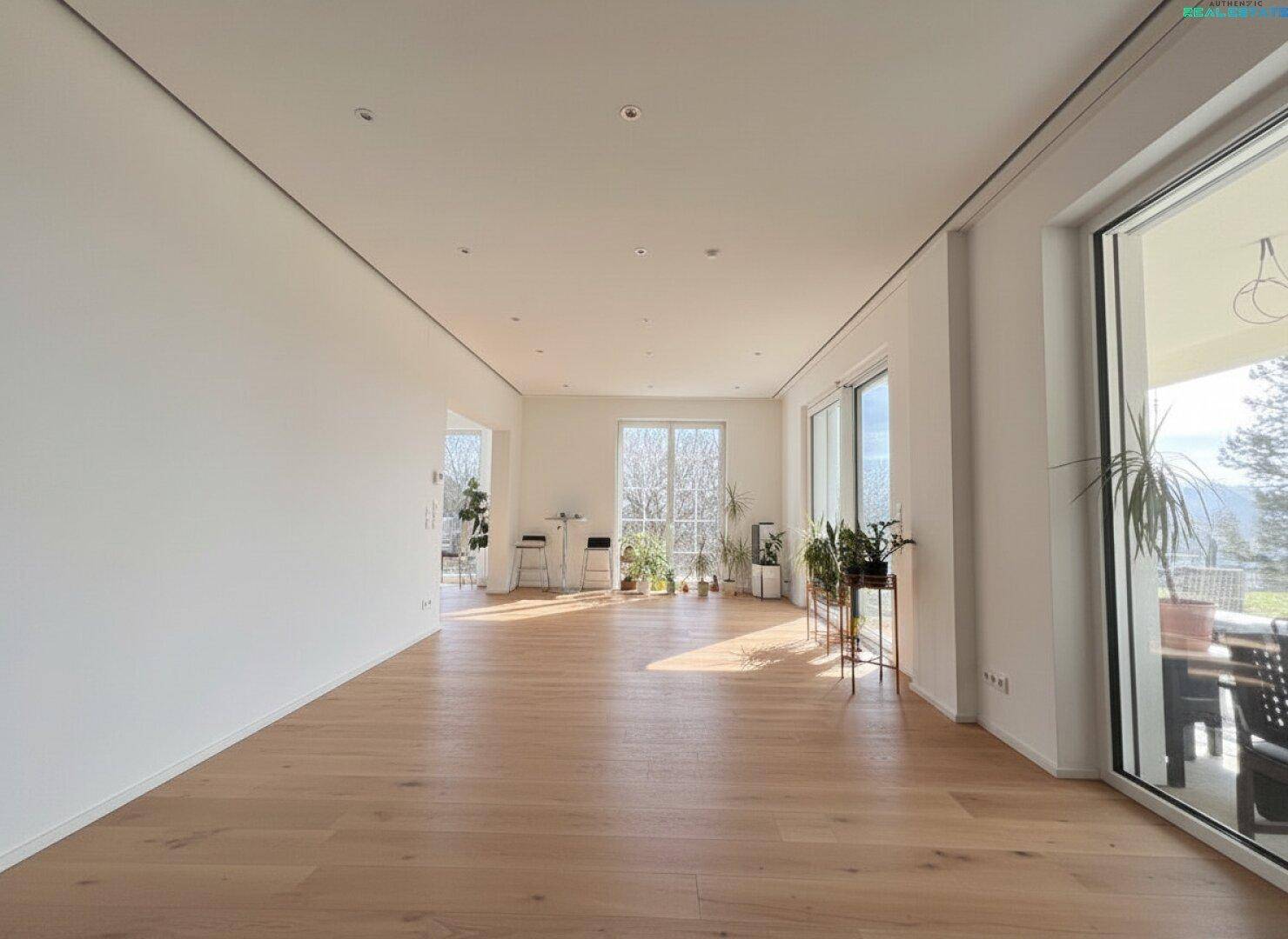 Weitläufiger Wohnbereich mit viel Tageslicht und Blick ins Grüne, ideal für Entspannung.