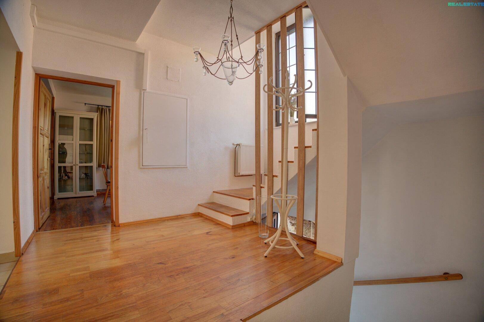 Heller Eingangsbereich mit Holzfußboden und Treppe zum Obergeschoss.