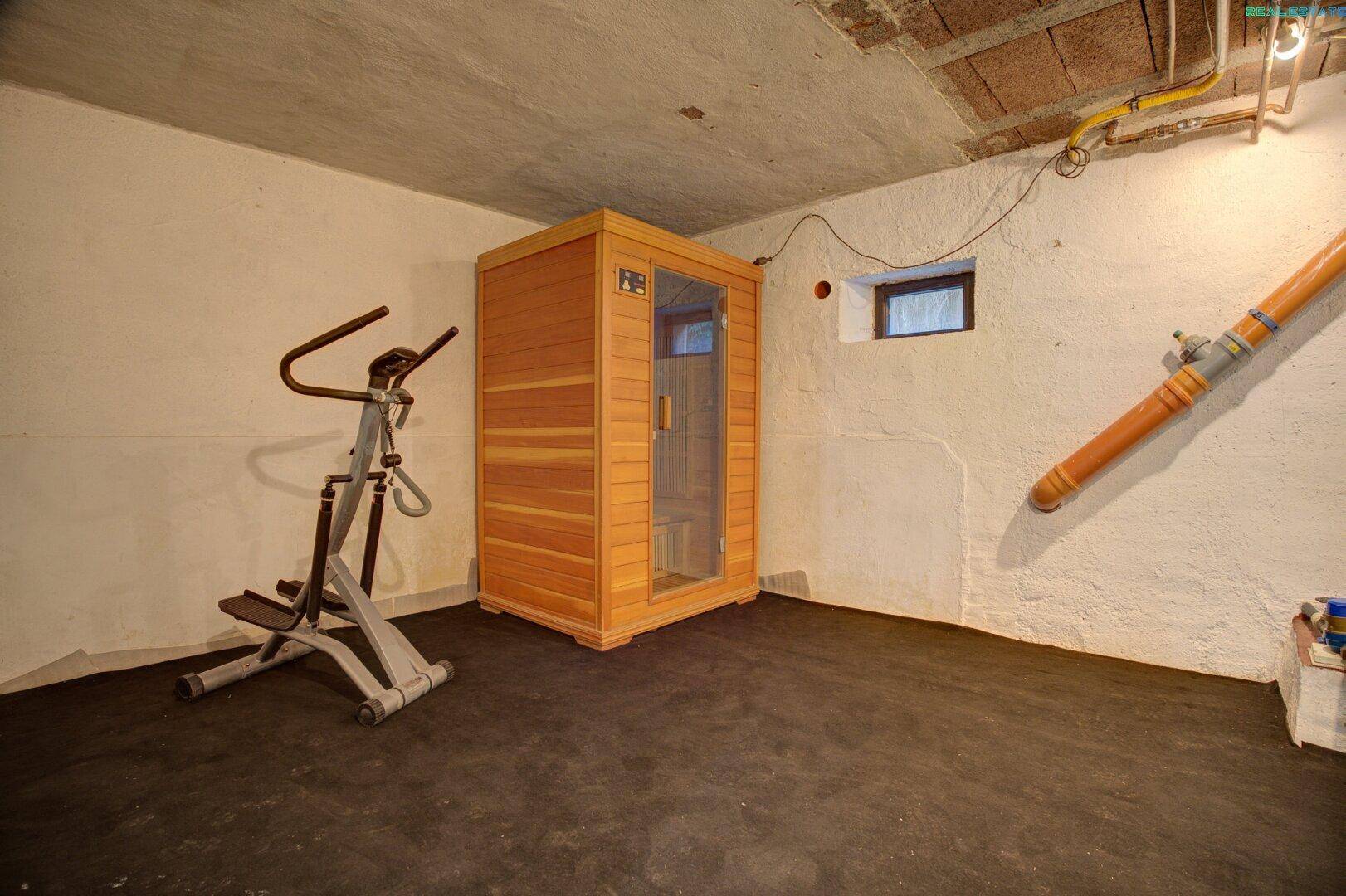 Kellerraum mit Sauna und Fitnessgerät.