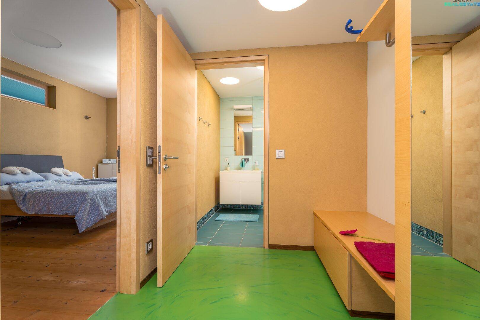 Flur mit grünem Boden, Holztüren und Zugang zu Schlafzimmer und Badezimmer.