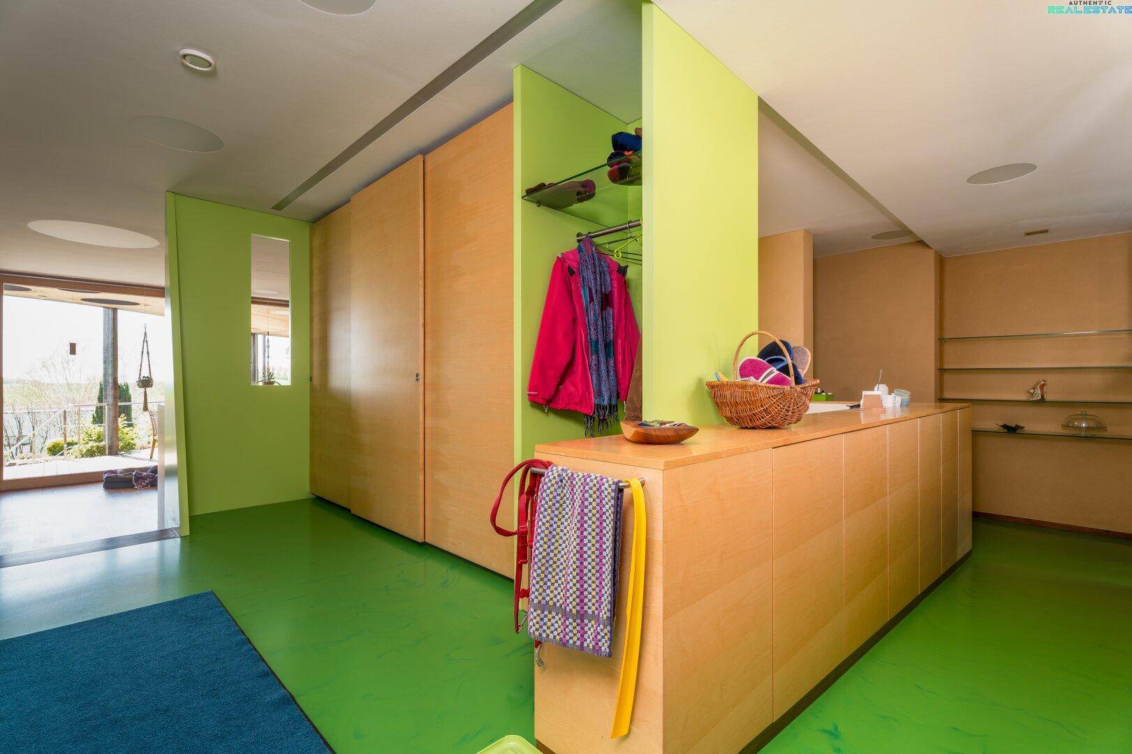 Funktionaler Bereich mit grünem Boden, Einbauschränken und Garderobe.