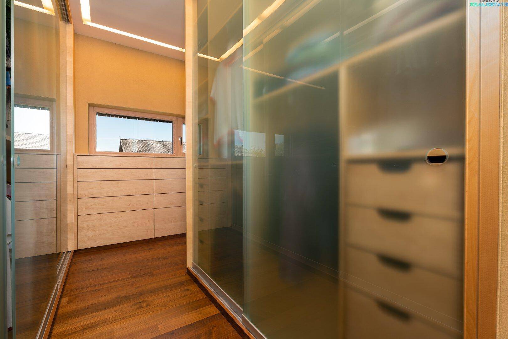 Geräumiger begehbarer Kleiderschrank mit viel Stauraum und integrierten Schubladen.