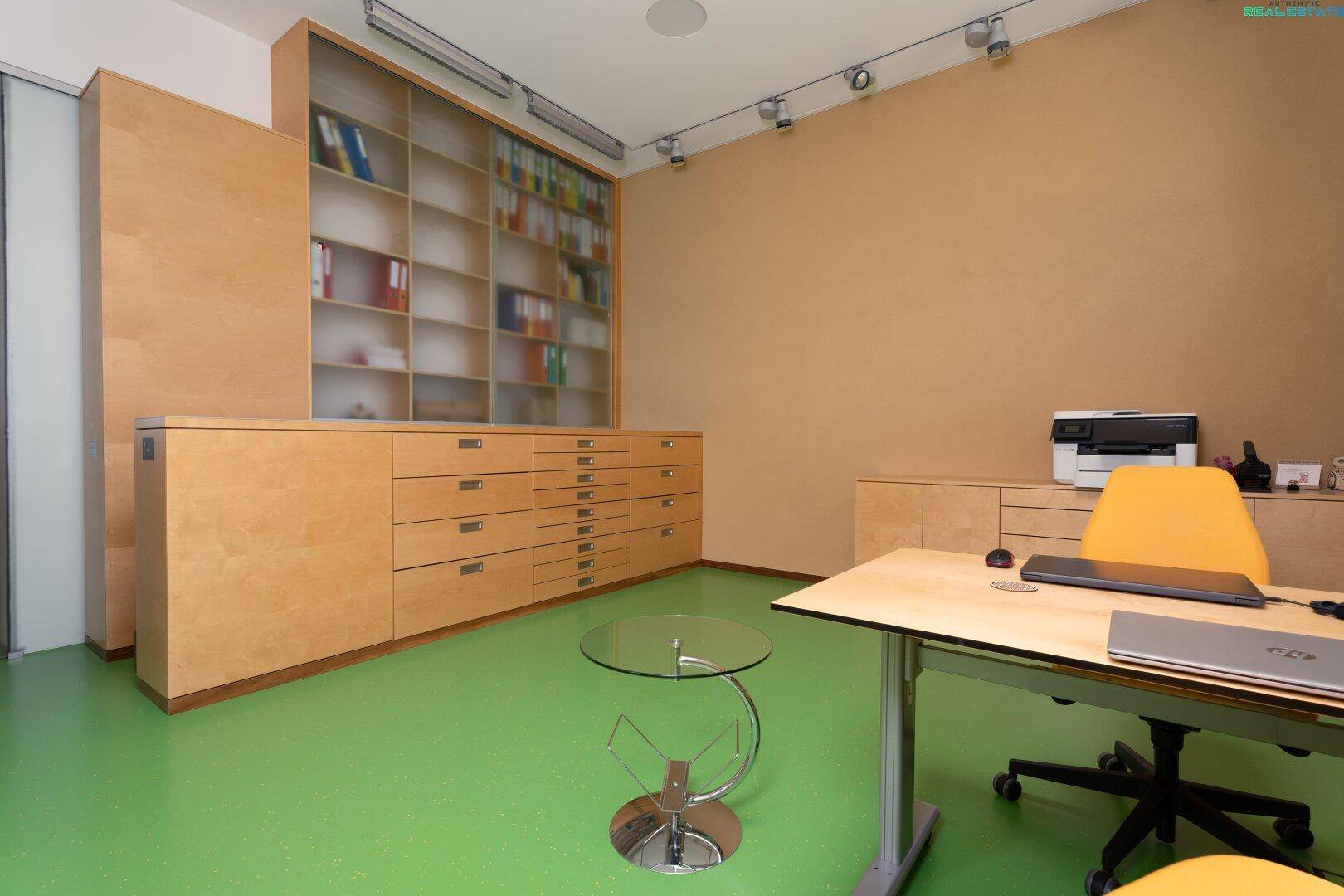 Geräumiges Büro mit Einbauschränken, viel Stauraum und modernem Schreibtisch.