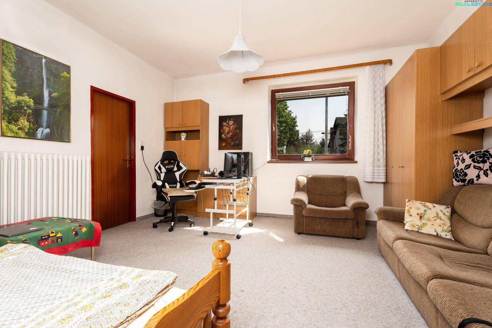 Geräumiges Zimmer mit Teppichboden, Schreibtisch und Sofa, ideal als Schlaf- oder Arbeitszimmer.