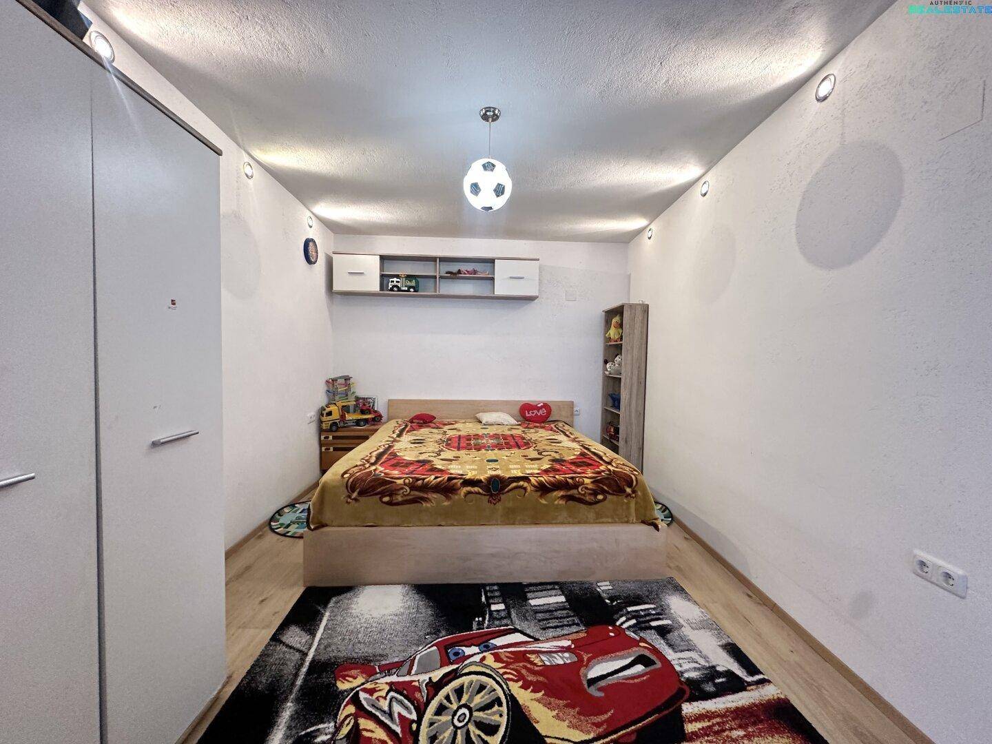 Kinderzimmer mit Holzboden, Kleiderschrank und einem Bett.