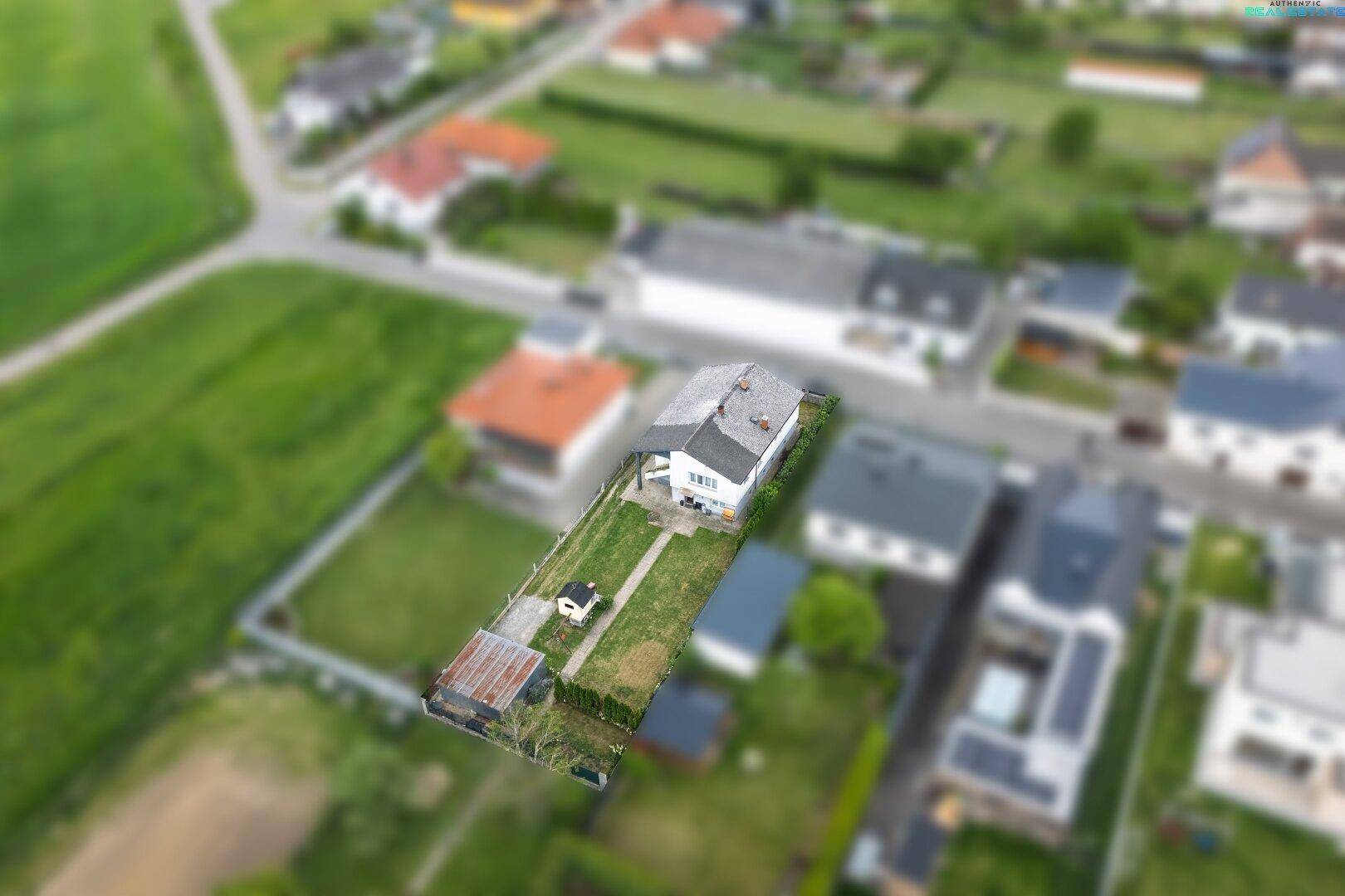 Luftaufnahme eines Einfamilienhauses mit Garten in ländlicher Umgebung.
