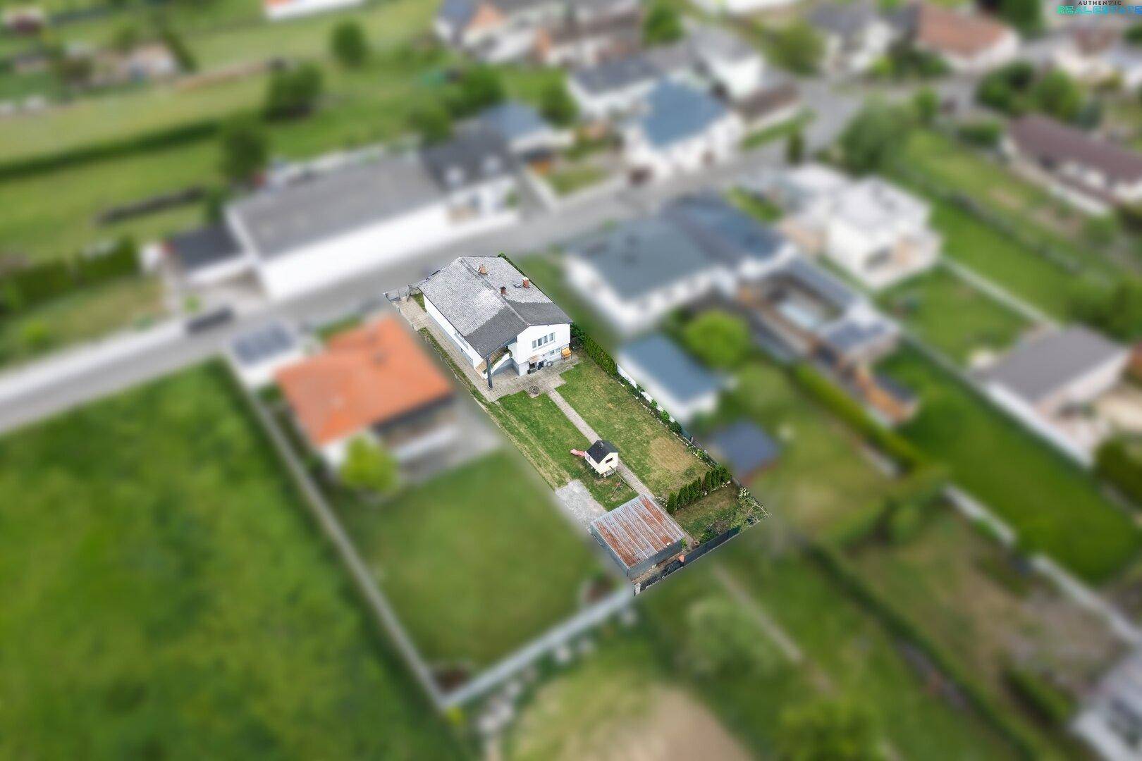Vogelperspektive eines Hauses mit großem Garten und umliegender Landschaft.