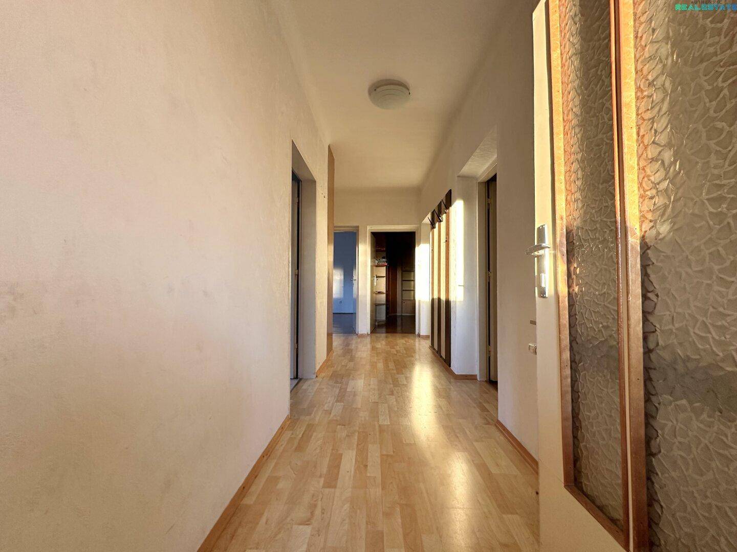 Heller Flur mit Laminatboden und Türen zu verschiedenen Räumen.