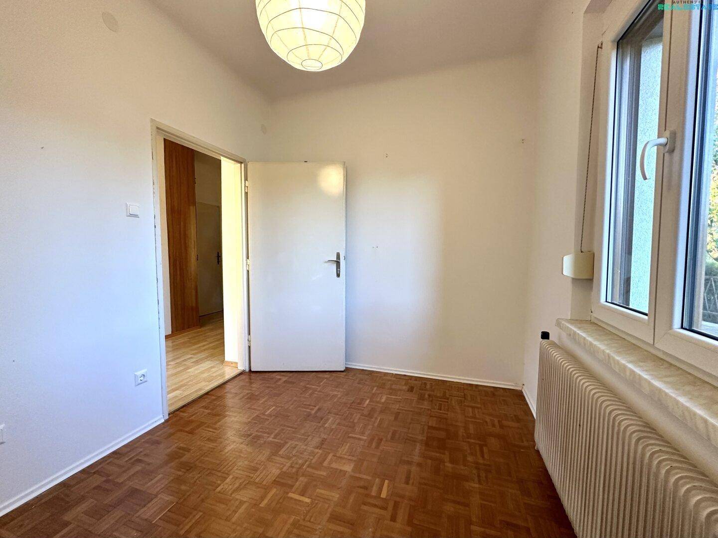 Kleines Zimmer mit Parkettboden, Fenster und Heizkörper, bereit zur individuellen Gestaltung.
