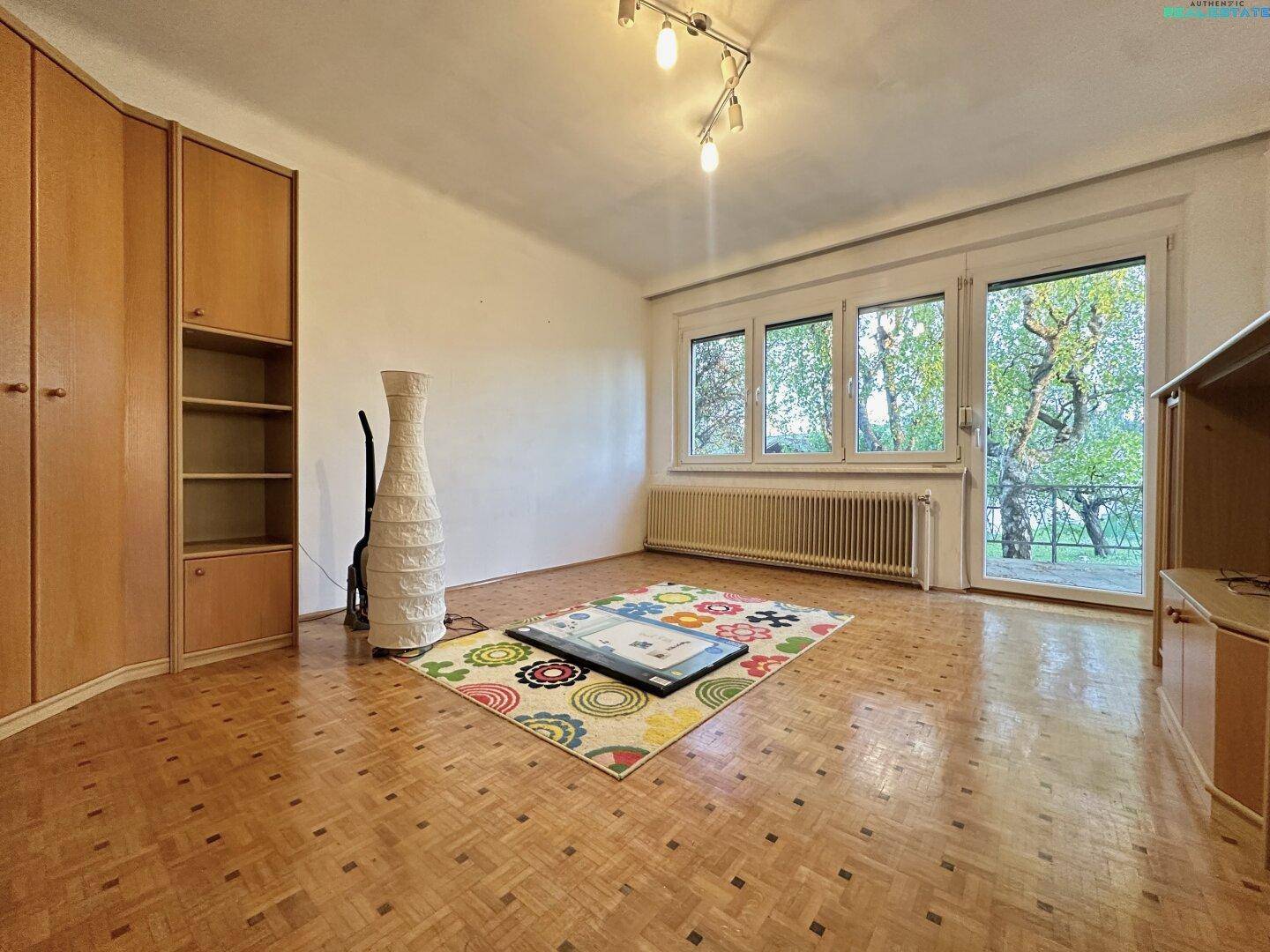 Helles Zimmer mit Parkettboden, Einbauschränken und Zugang zur Terrasse oder Balkon.