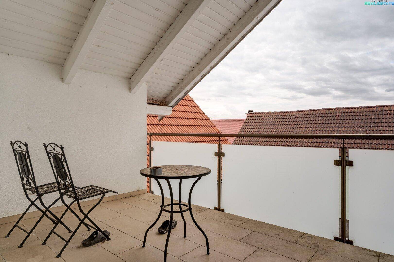 Überdachter Balkon mit Fliesenboden und Sitzgelegenheiten, ideal für entspannte Stunden im Freien.