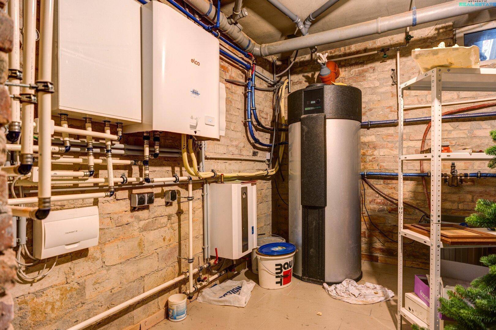 Heizungsraum im Keller mit moderner Heizungsanlage und Warmwasserspeicher, gut gewartet.