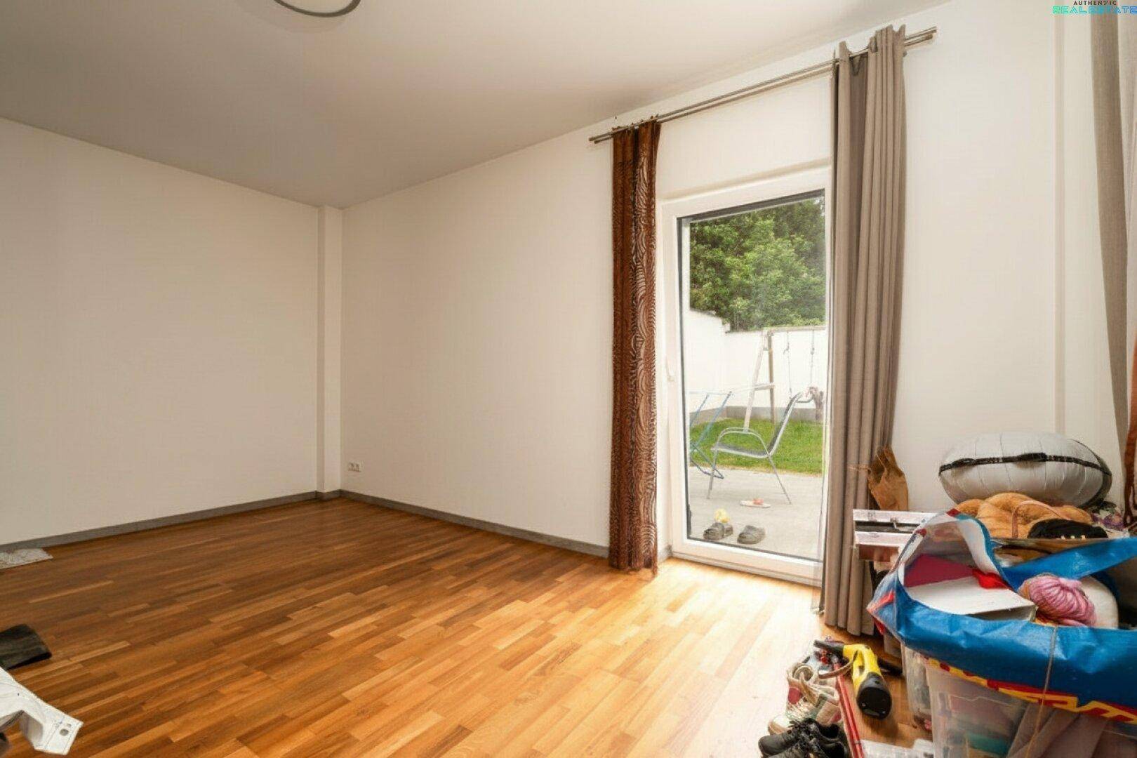 Vielseitiger Raum mit Holzboden und direktem Zugang zum Gartenbereich, flexibel nutzbar.