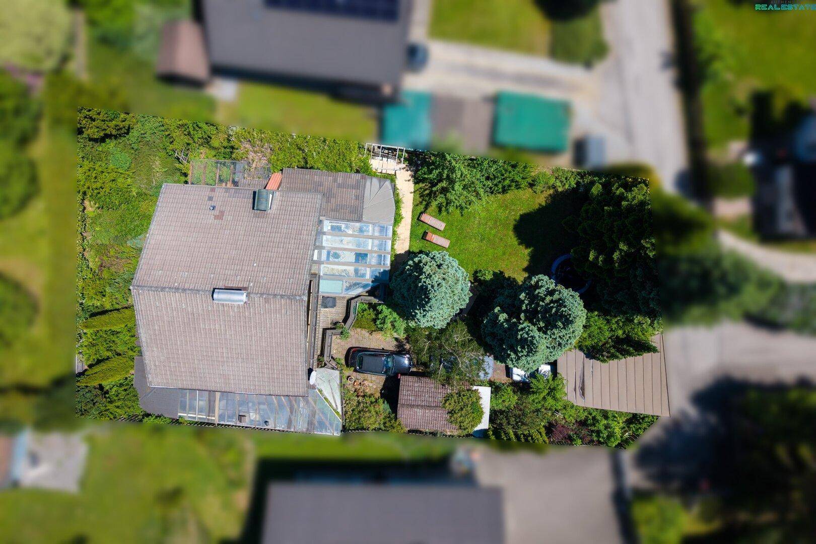 Vogelperspektive des Anwesens mit Haus, Garten, Parkplatz und angrenzenden Grundstücken.