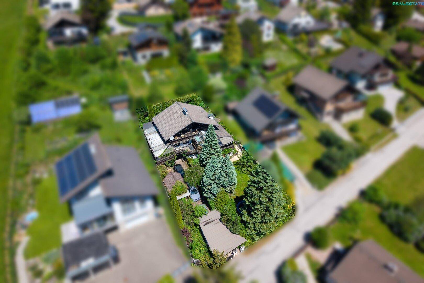 Weitläufige Luftaufnahme des Anwesens und der Nachbarschaft mit viel Grün und Häusern.