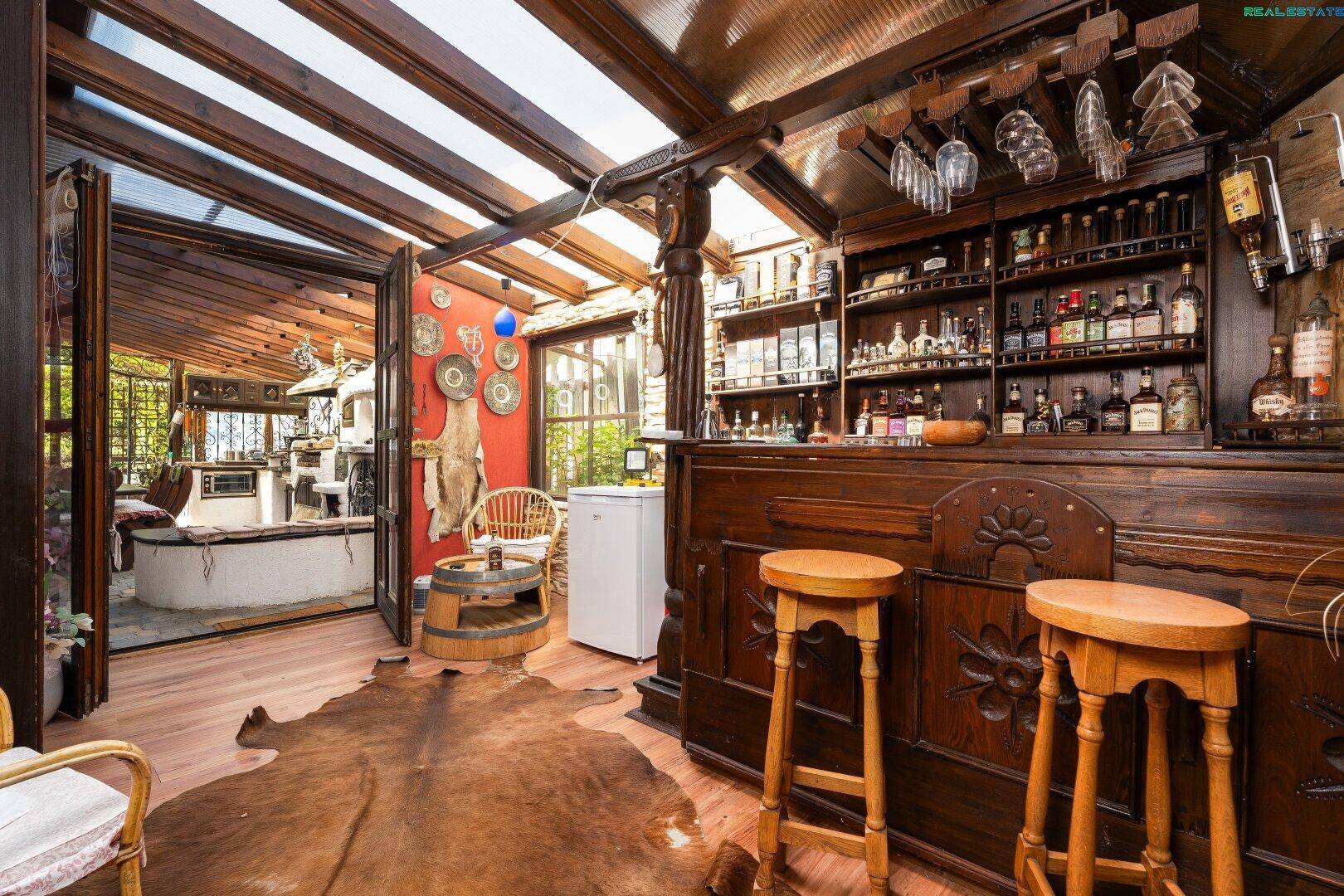 Rustikale Hausbar mit Holzeinrichtung, reichhaltiger Getränkeauswahl und gemütlicher Atmosphäre.