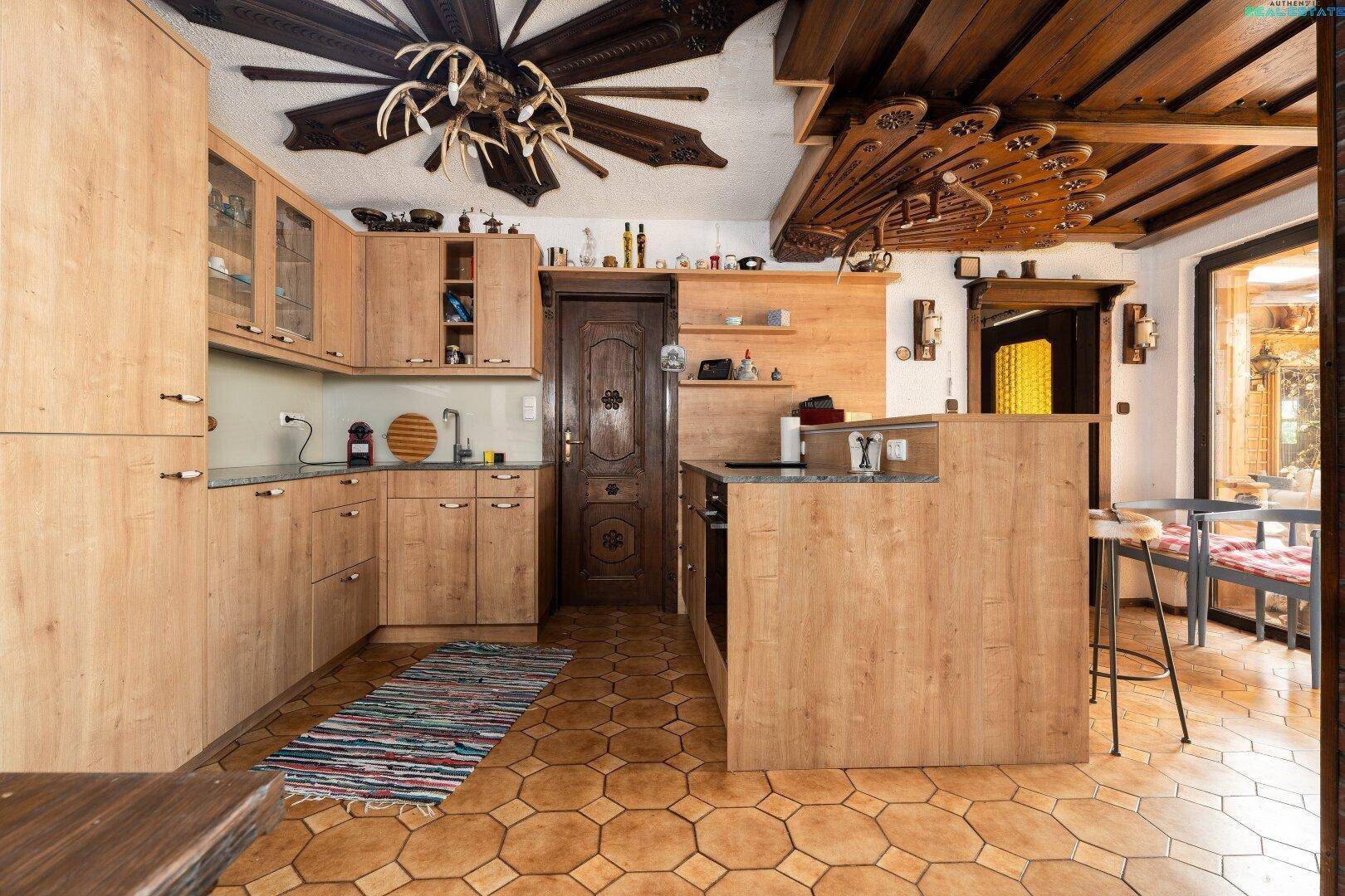 Helle Holzküche mit modernen Geräten, Kücheninsel und traditionellen Akzenten.