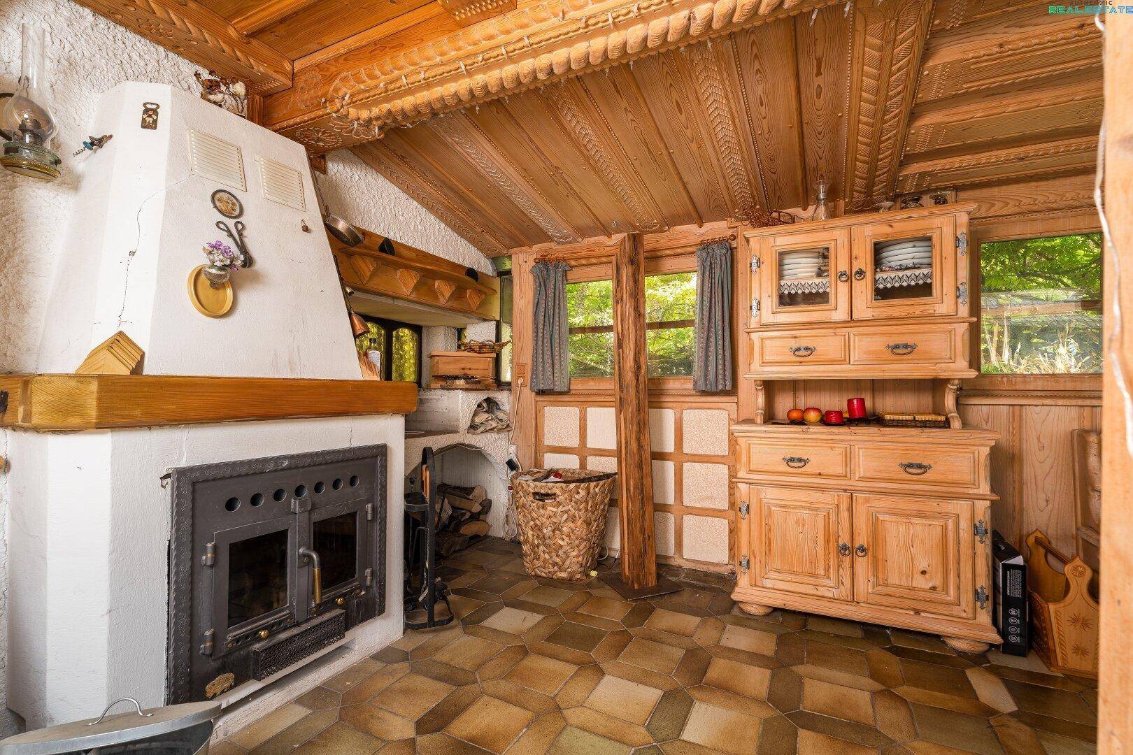 Gemütlicher Bereich mit großem Kamin, Holzschrank und traditioneller Einrichtung.