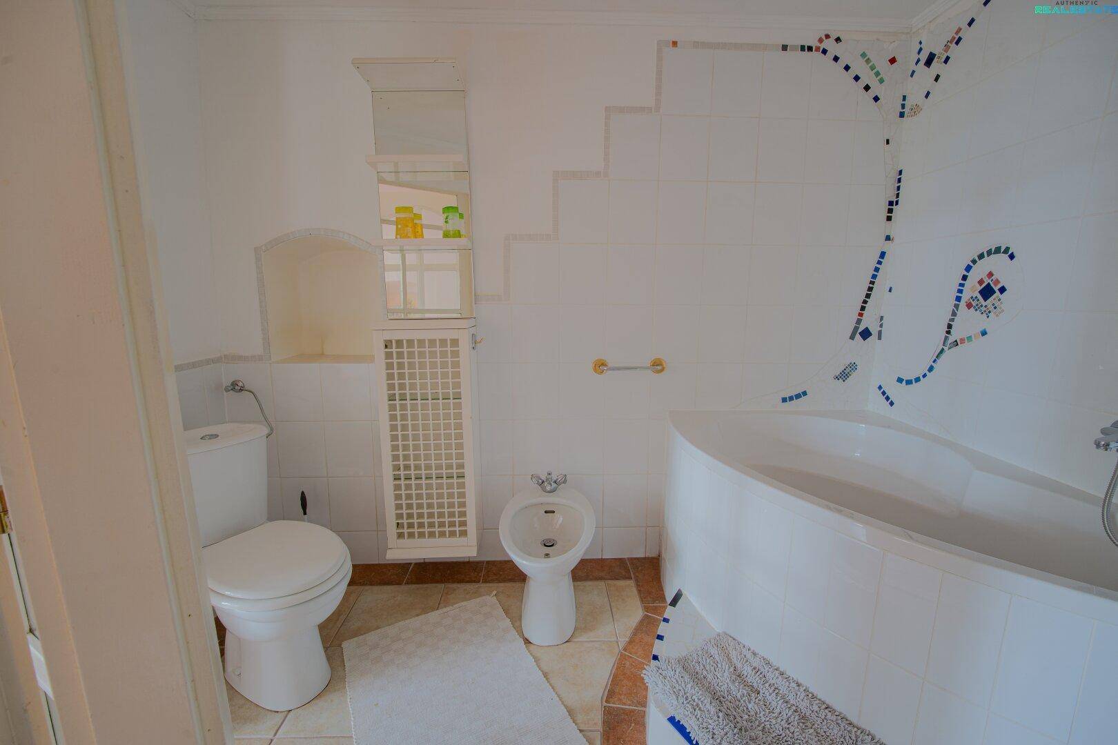 Badezimmer mit Badewanne, Bidet und dekorativen Mosaikfliesen an der Wand.