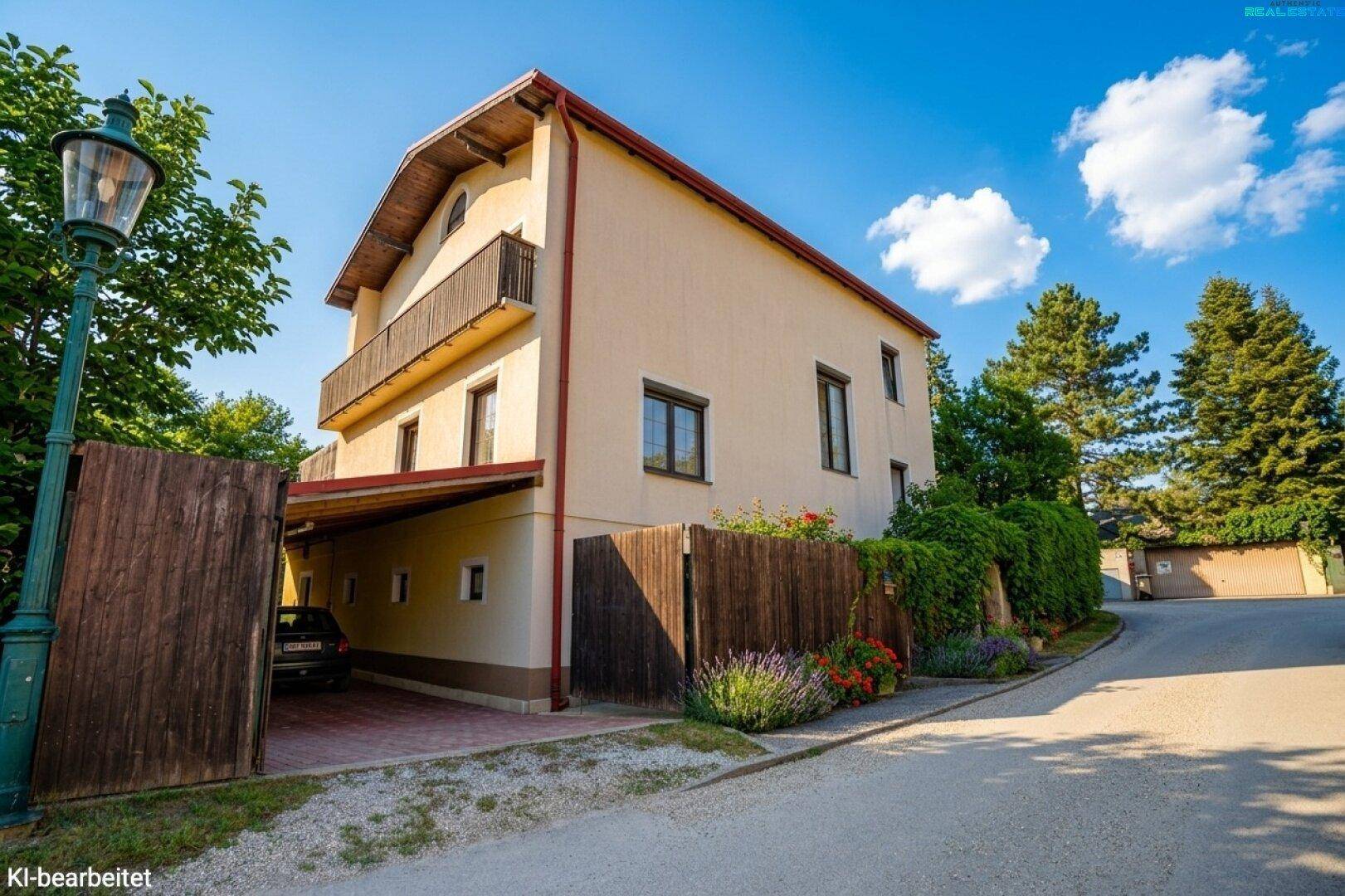 Ansicht des Einfamilienhauses von der Straße mit Carport und kleinem Balkon.