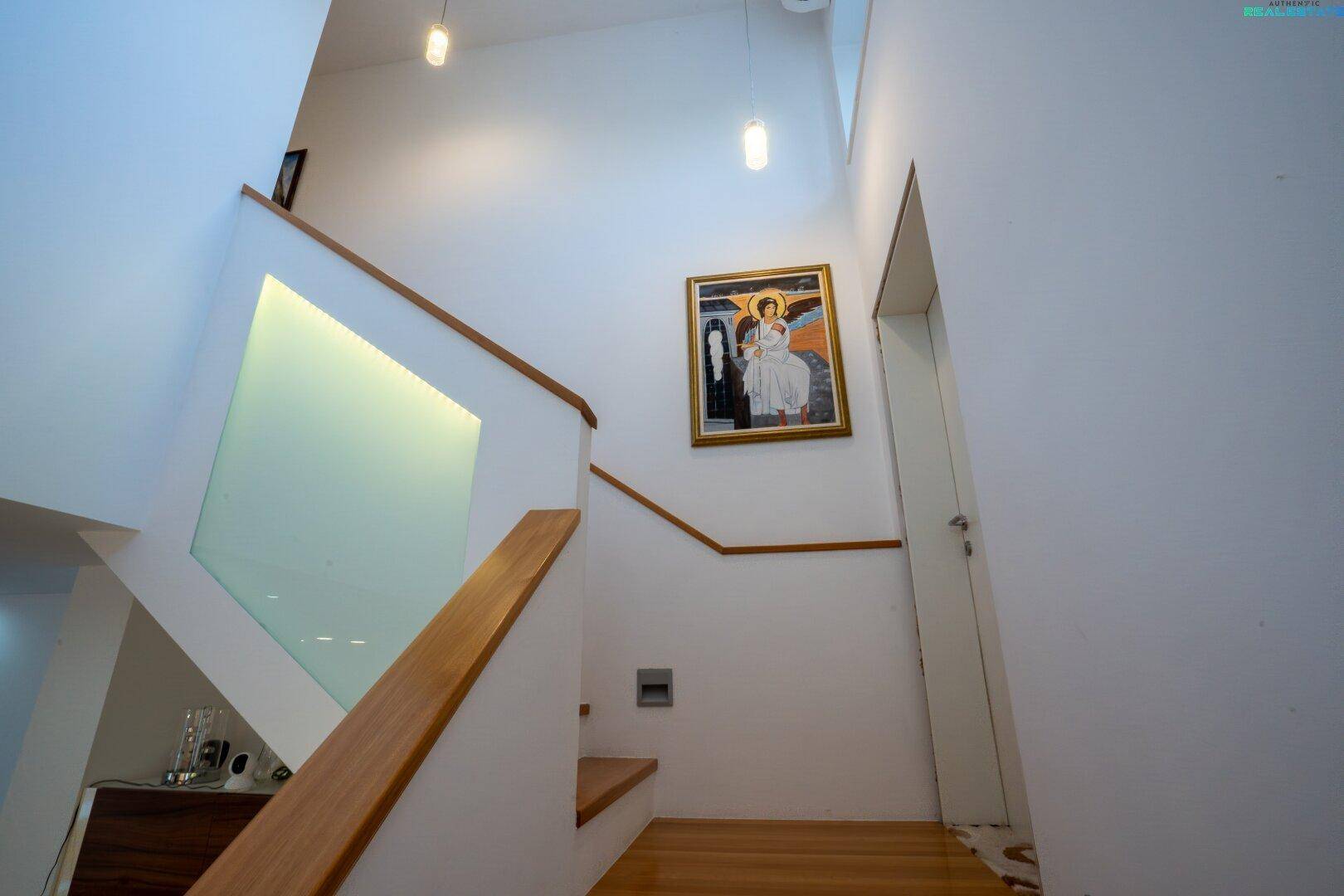 Moderne Holztreppe mit Glasgeländer und heller Wandgestaltung.