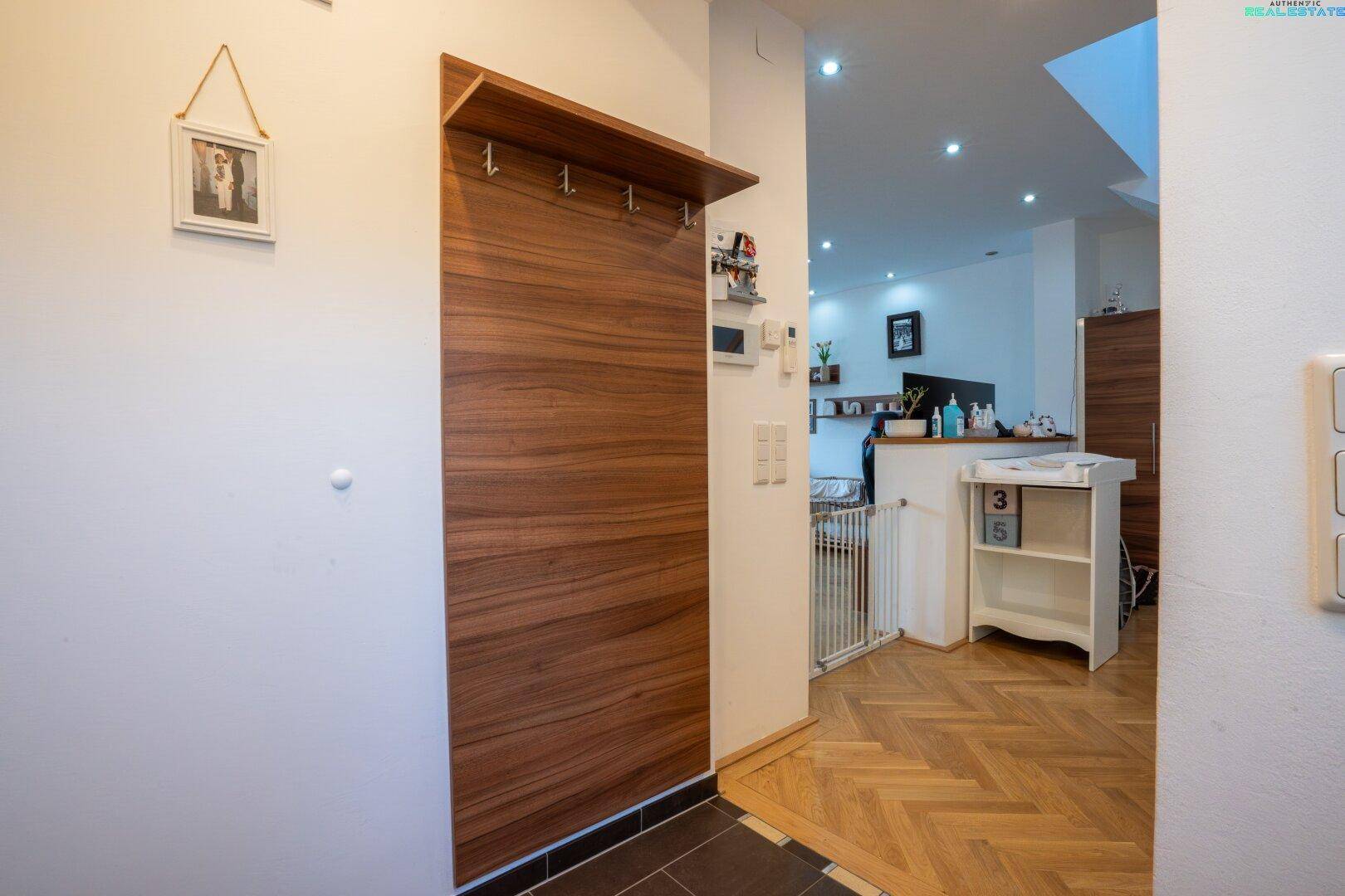 Eingangsbereich mit Garderobe, Fliesenboden und Blick in den Wohnbereich.