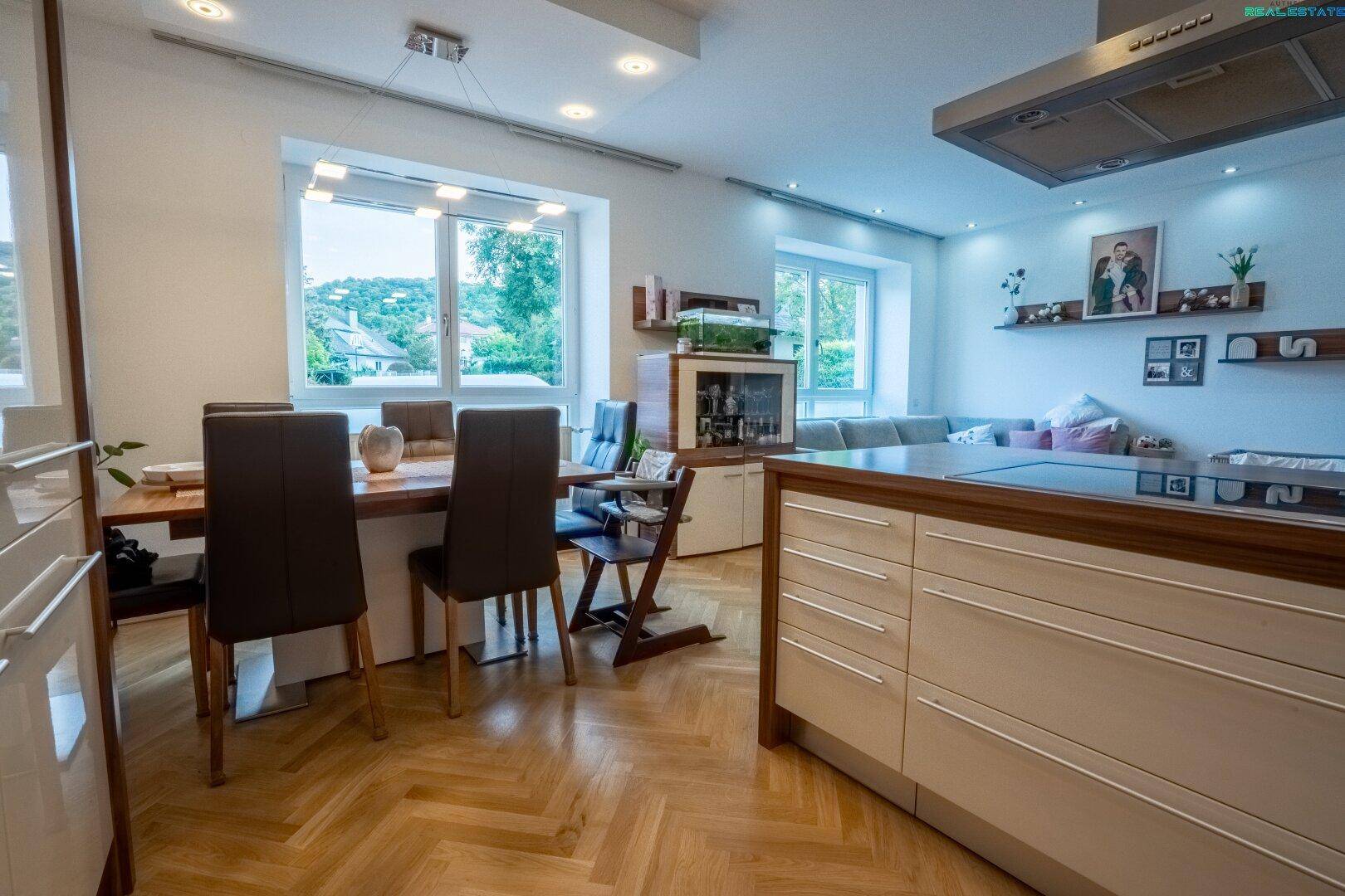Essbereich mit Holztisch und Stühlen, angrenzend an die offene Küche und das Wohnzimmer.