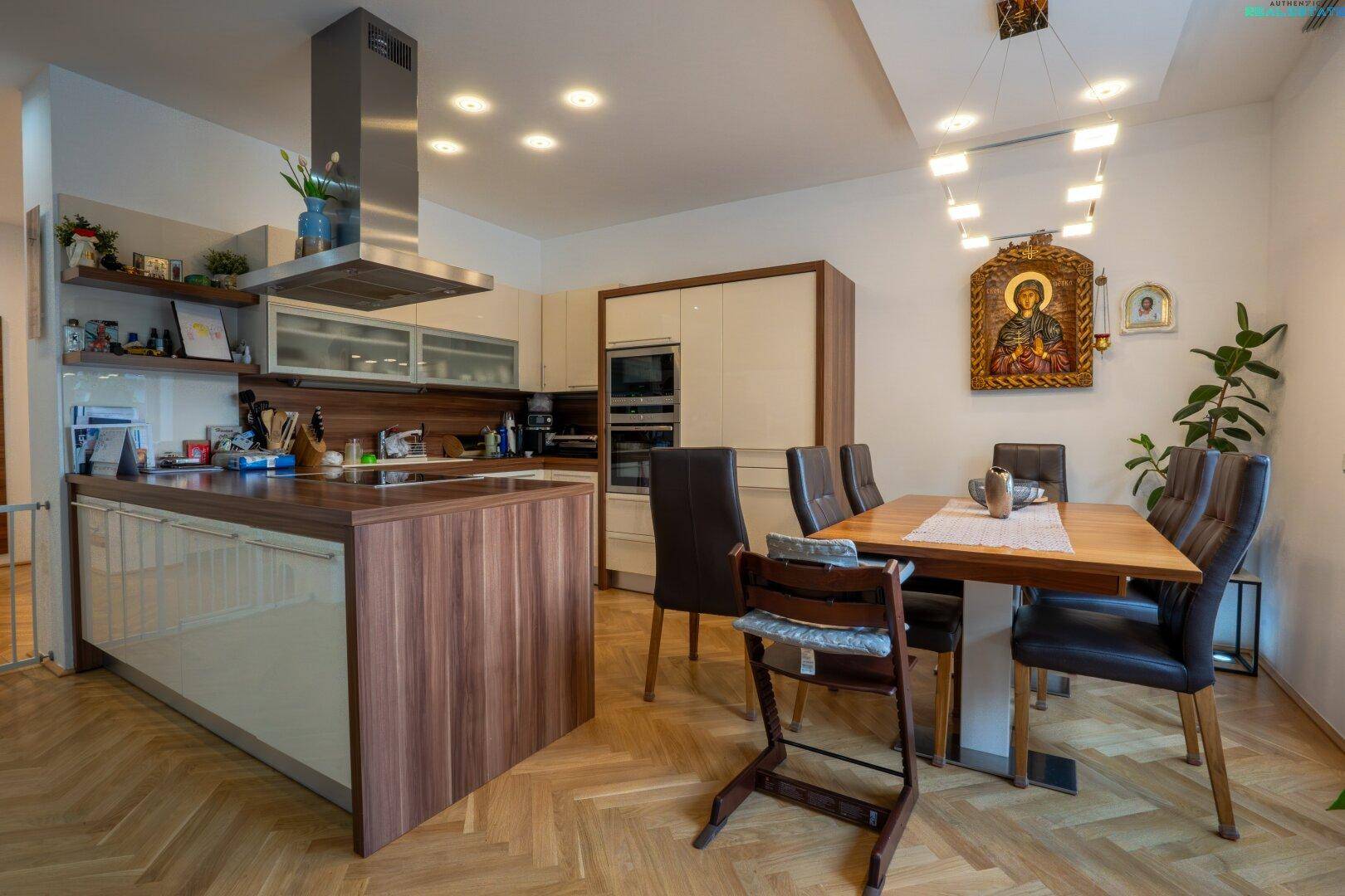 Moderne Küche mit Kochinsel und Essbereich, offen zum Wohnzimmer.