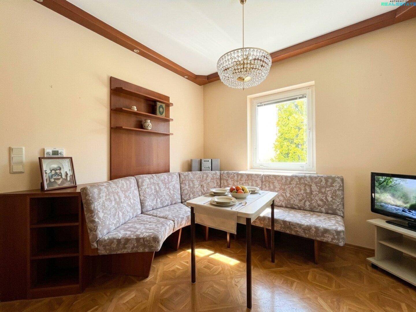 Gemütlicher Essbereich mit Eckbank, Holzbalken und Kronleuchter, ideal für Familienmahlzeiten.