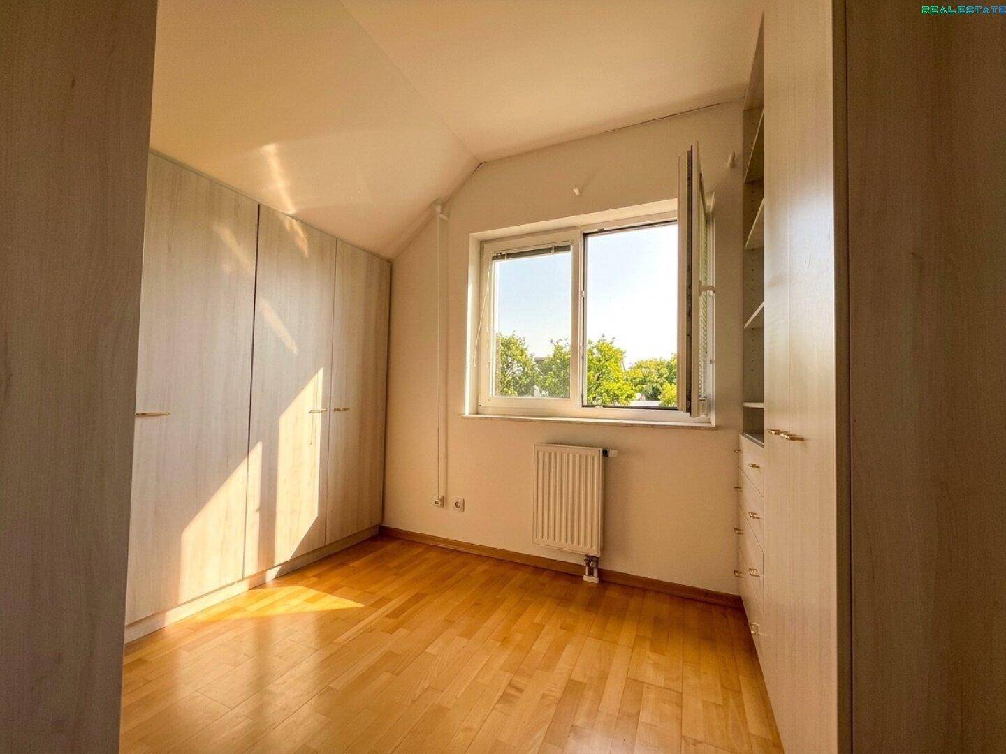 Helles Schlafzimmer mit Parkettboden und Einbauschränken, ideal für Stauraum.