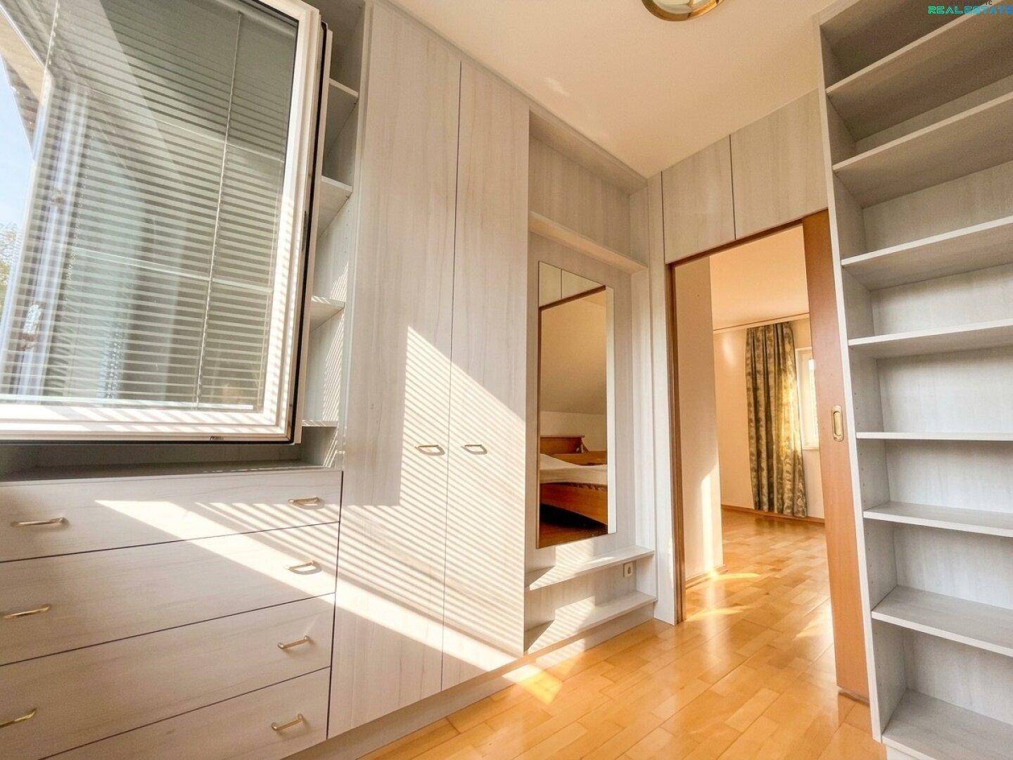 Geräumiger begehbarer Kleiderschrank mit Einbauschränken und viel Stauraum.