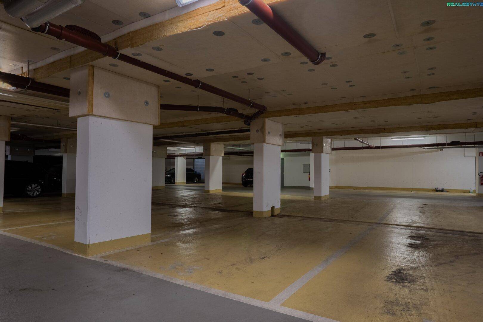 Geräumige Tiefgarage mit markierten Parkplätzen und Säulen.