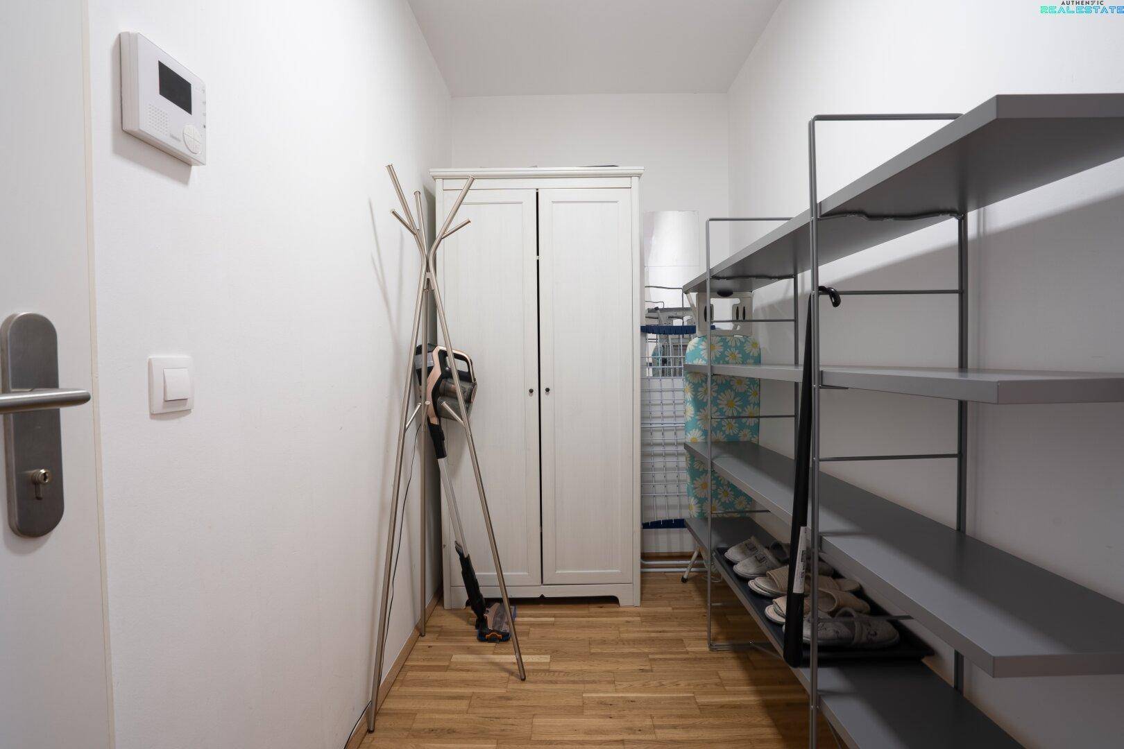 Eingangsbereich mit praktischen Schuhregalen, Garderobe und Holzboden.