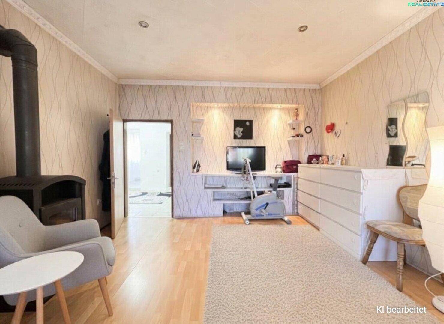 Wohnbereich mit Holzboden, gemusterter Tapete und einem modernen Holzofen als Wärmequelle.