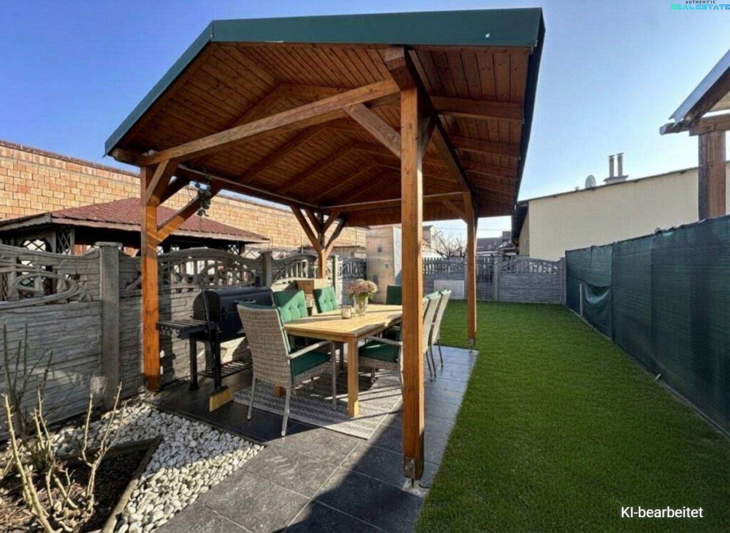 Überdachte Terrasse mit Holzdach, Essbereich und Grillplatz, umgeben von Rasen und Kies.