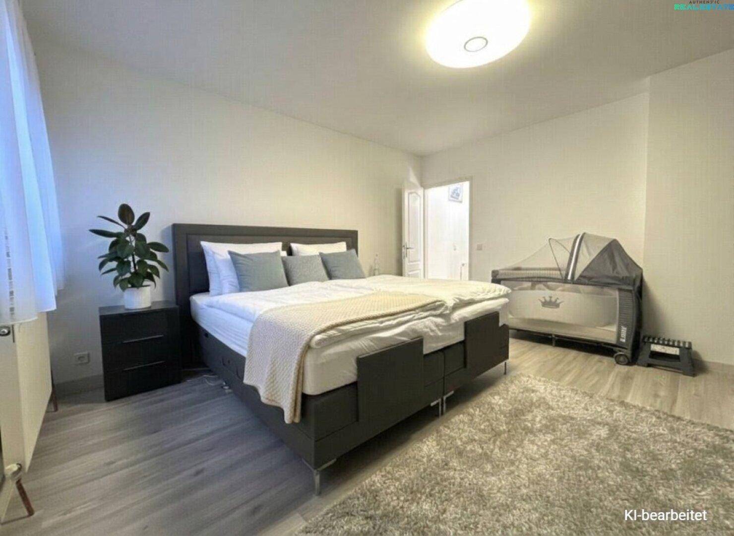 Helles Schlafzimmer mit Doppelbett, Nachttischen, Zimmerpflanze und Babybett.