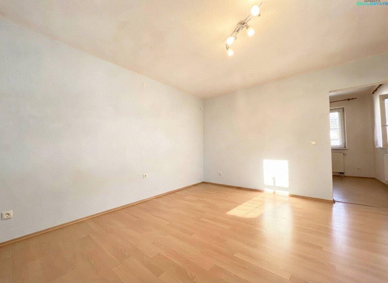 Heller, leerer Raum mit weißen Wänden, Holzfußboden und Deckenstrahlern, ideal für individuelle Gestaltung.