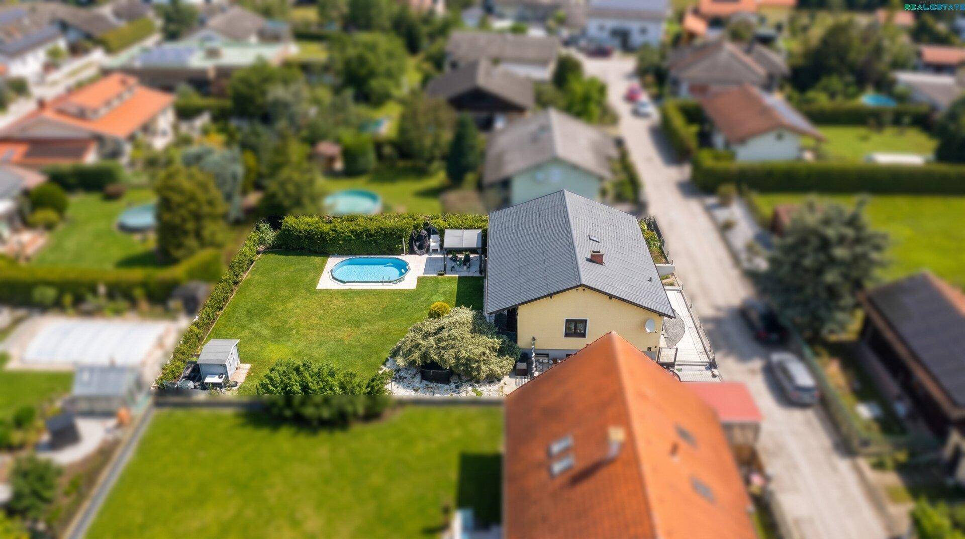 Übersicht des Anwesens von oben mit großem Garten, Pool und angrenzenden Häusern.