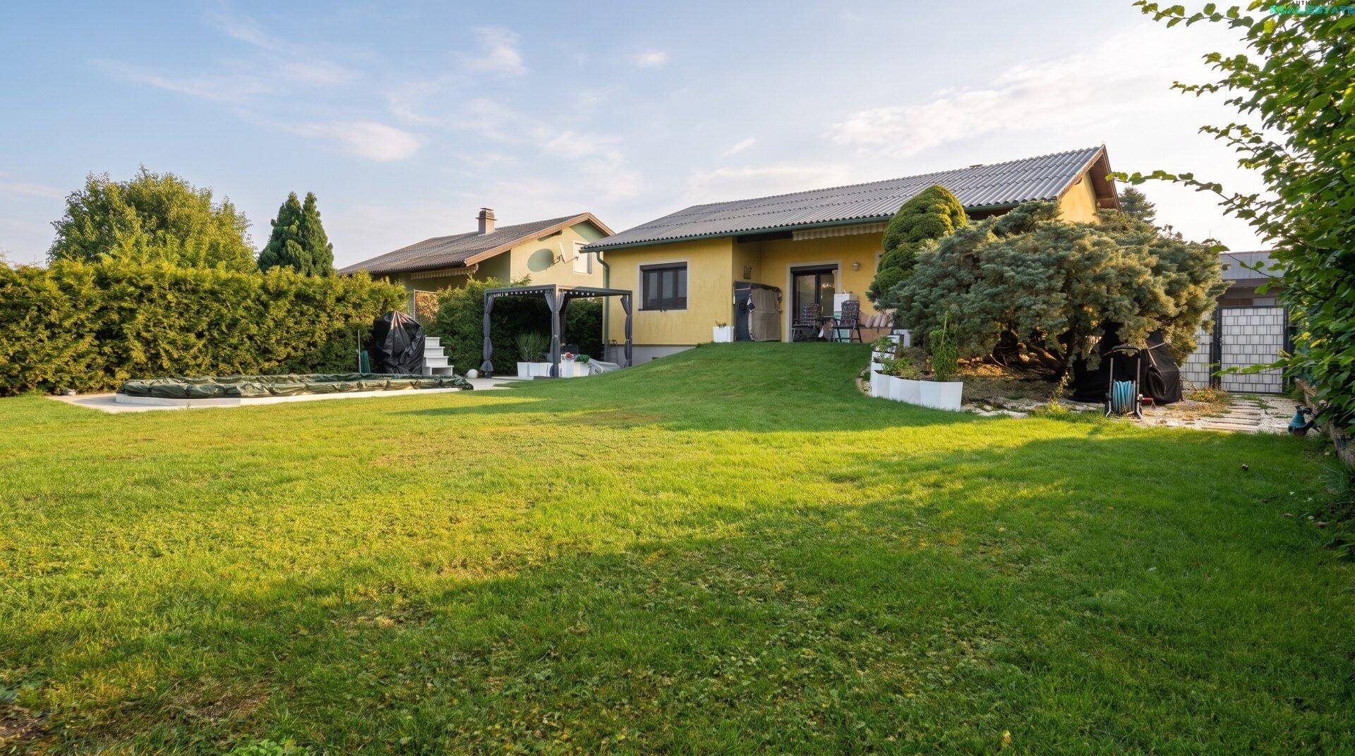 Großer, gepflegter Garten mit weitläufiger Rasenfläche, überdachtem Pool und Pergola.
