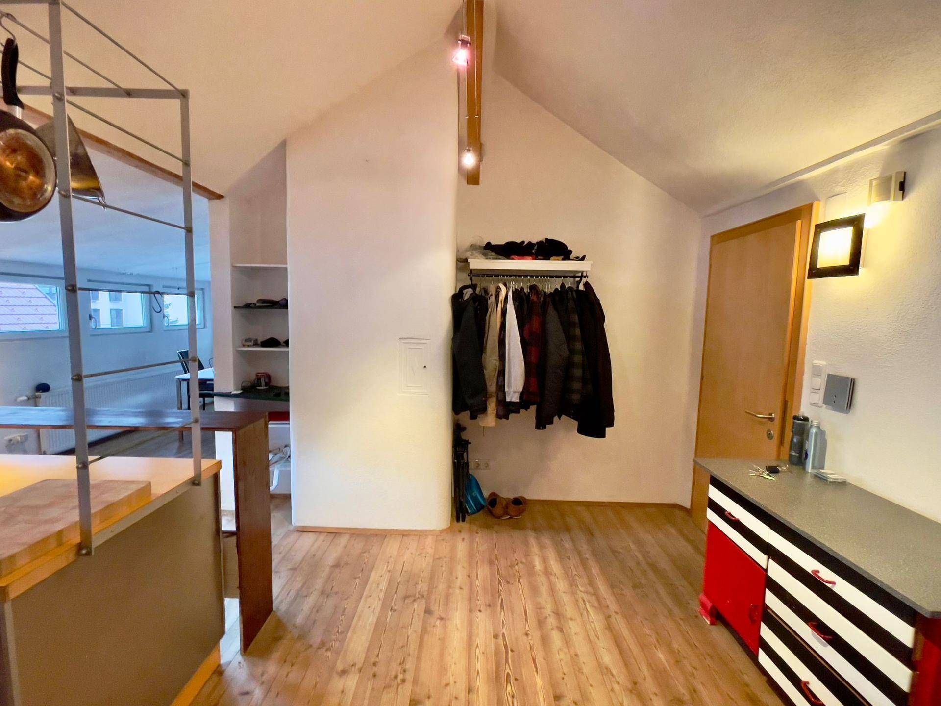 Flur mit Garderobe, Holzboden und Zugang zu den verschiedenen Räumen.